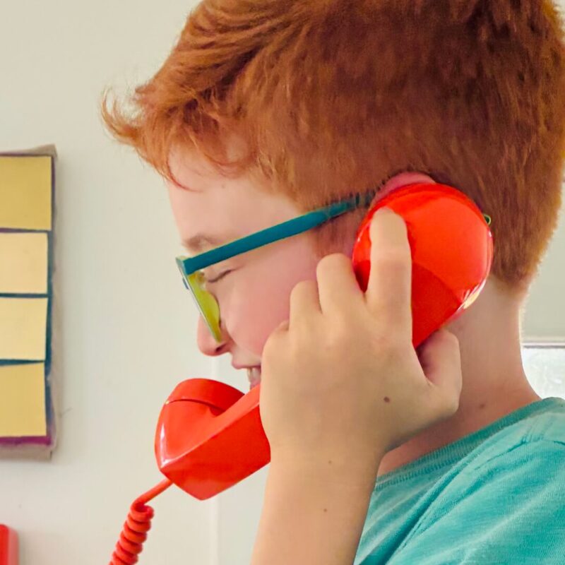 Middle School male student on phone smiling