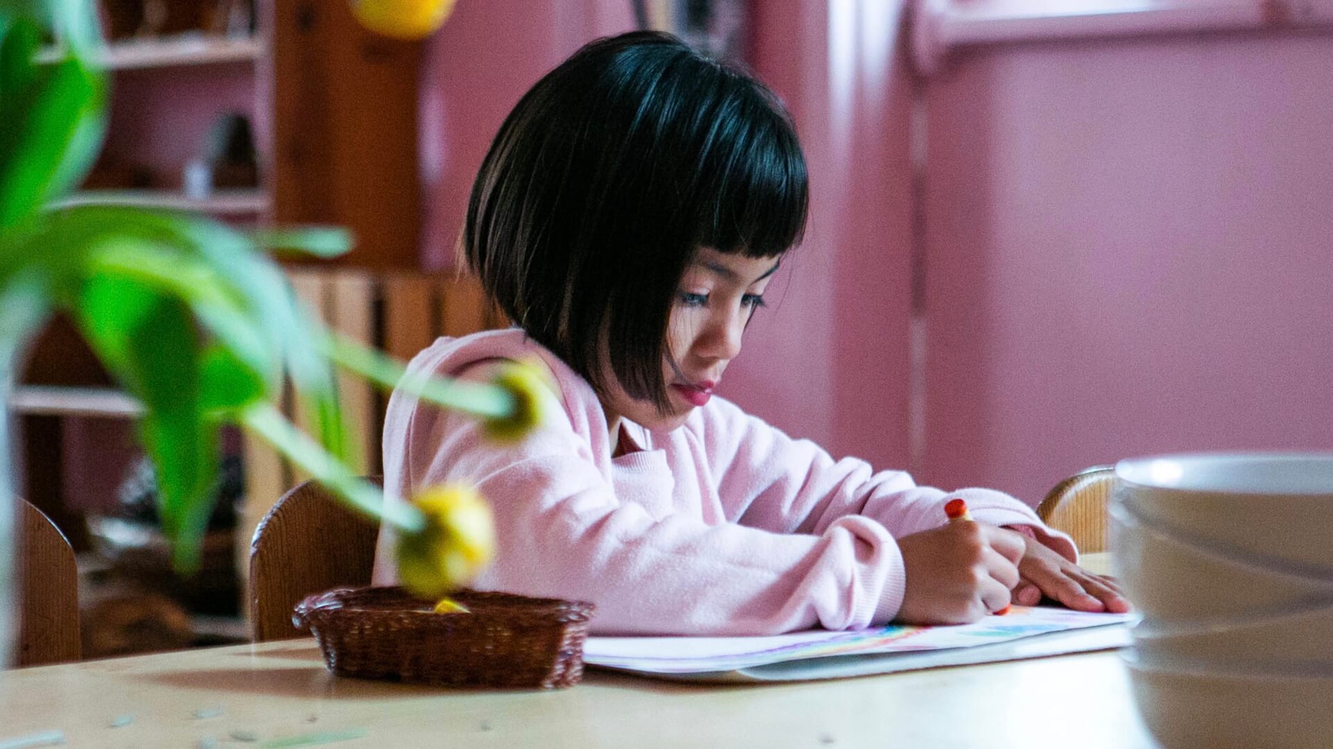 Early school female student coloring artwork.