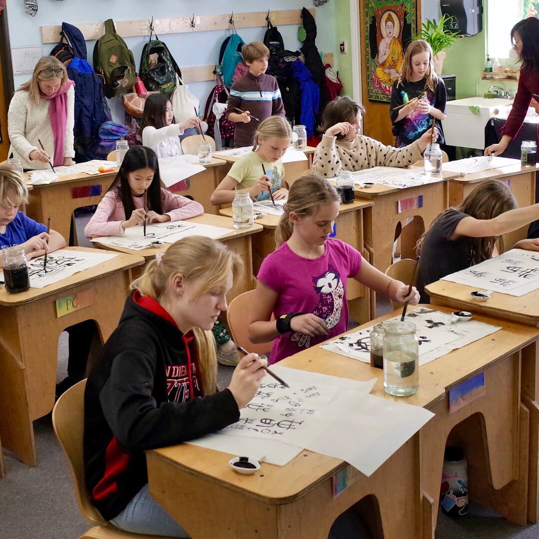 Lower school students in art class painting with watercolors.