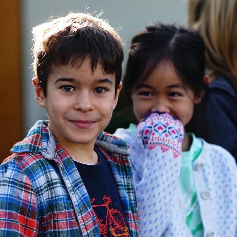 Lower school male and female students stand in line.