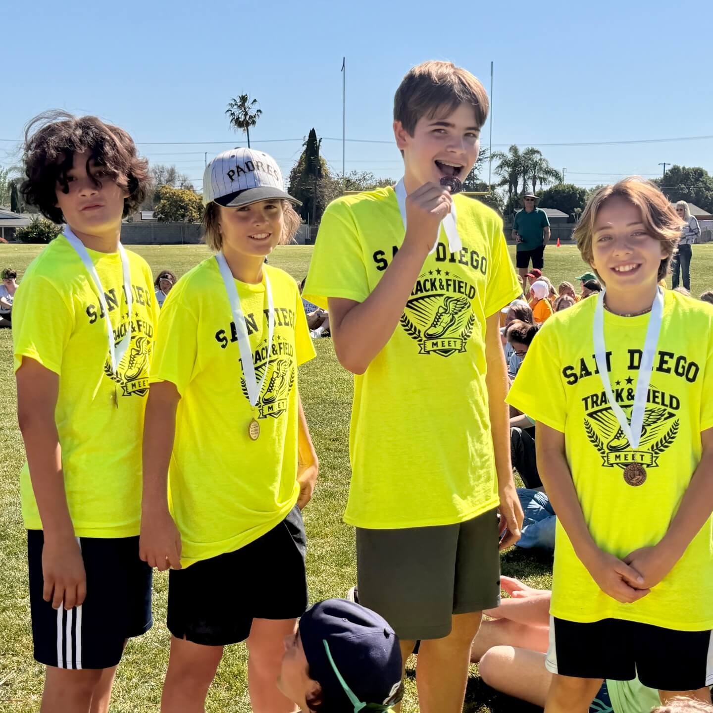Middle School male and female students in track and field, wearing medals.