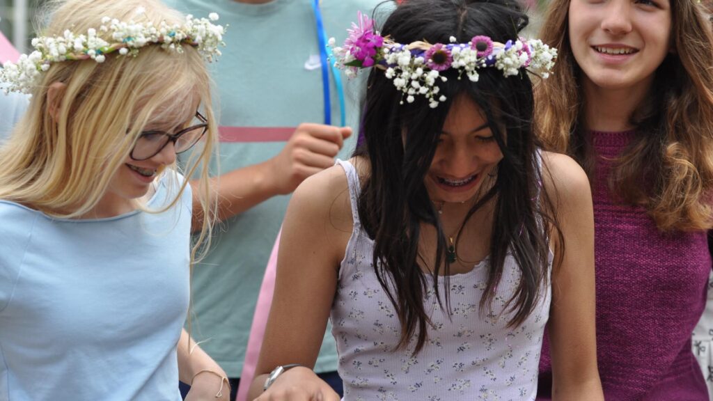 Middle School female students outdoors wearing wreaths.