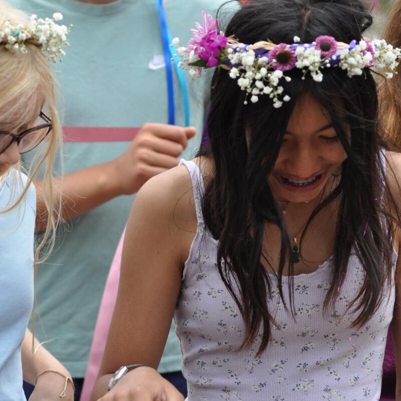 Middle School female students outdoors wearing wreaths.