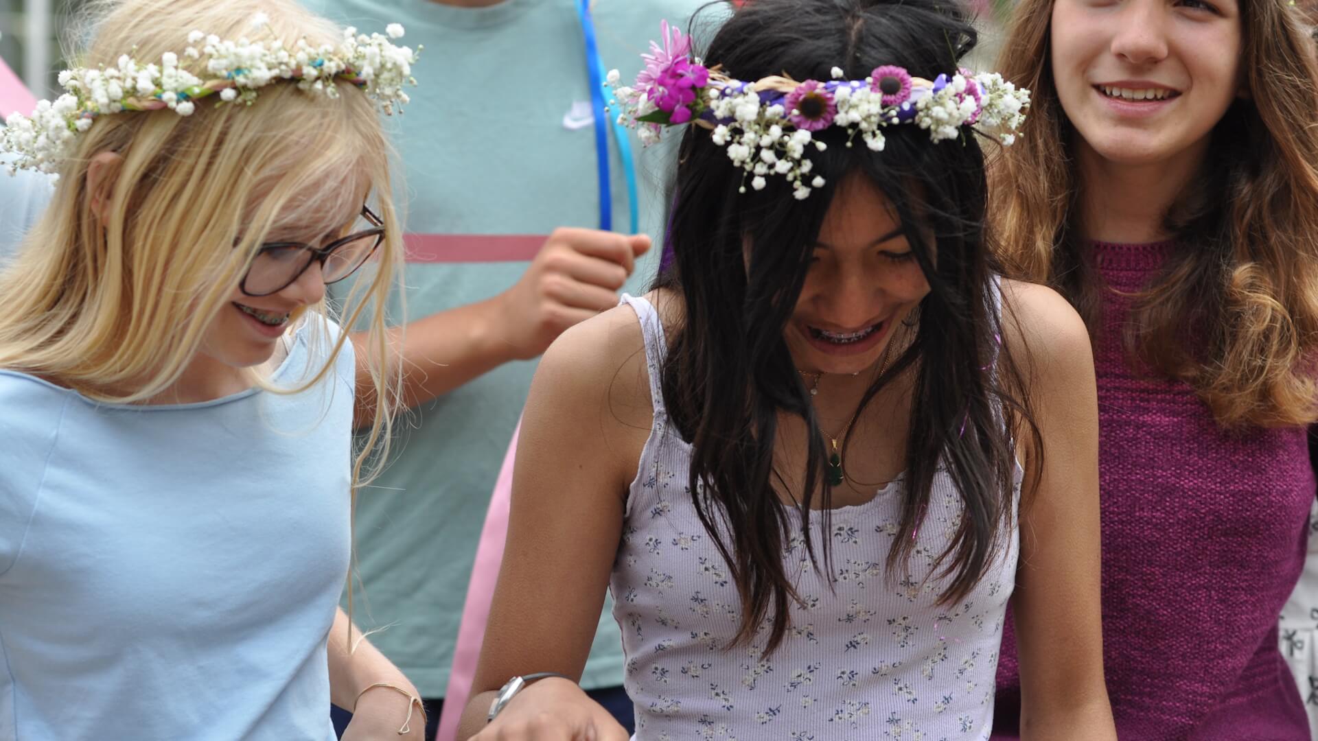 Middle School female students outdoors wearing wreaths.