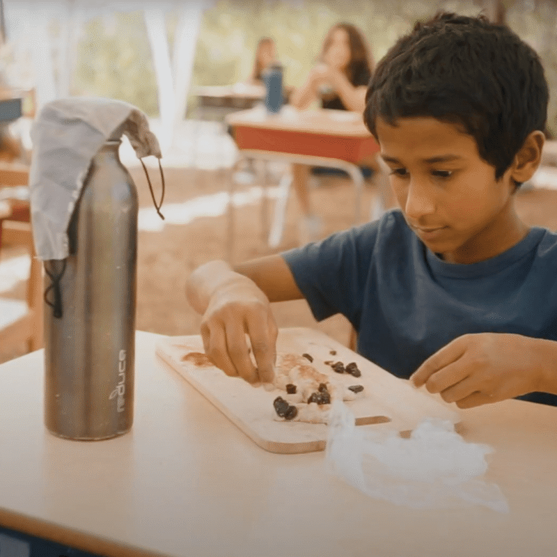 Lower School male student molds clay.