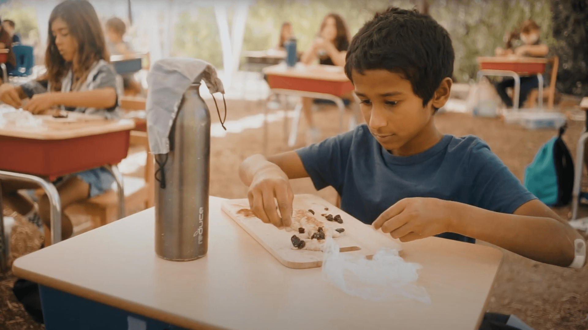 Lower School male student molds clay.