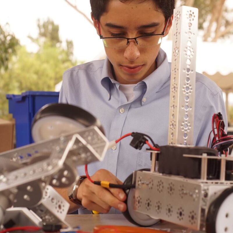 High School male student works with robotics