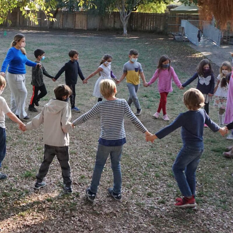 Lower School students in a circle in a field