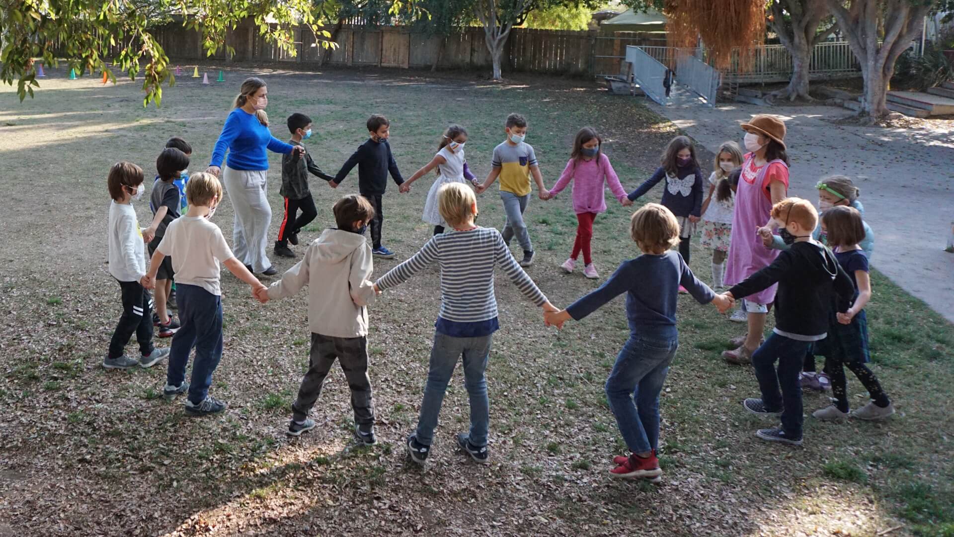 Lower School students in a circle in a field