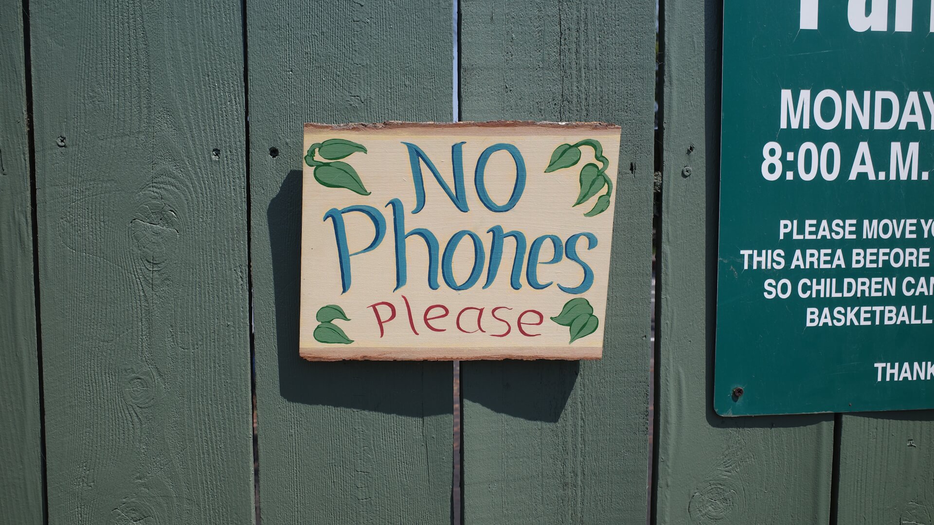 No phones please sign hanging on fence